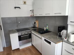 a small kitchen with white cabinets and a sink at VUE MER et montagne dans parc du roy d'espagne, Up to 7 people in Marseille