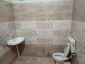 La salle de bains est pourvue de toilettes et d'un lavabo. dans l'établissement FYS cozy stays, à Kanpur