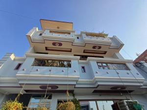 un grand bâtiment blanc avec un bâtiment dans l'établissement FYS cozy stays, à Kanpur