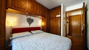 a bedroom with a bed with a red headboard at Hostdomus - Nebbiolo in Sestriere