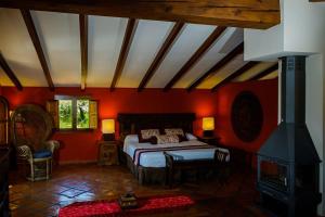 - une chambre avec un lit dans une pièce aux murs rouges dans l'établissement Masía Durbá B&B, à Castellnovo