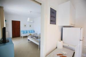 a living room with blue chairs and a refrigerator at The cozy nest:) in Batsi