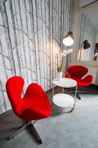 Pokój z 2 czerwonymi krzesłami i stołem w obiekcie Vigo Hotel w Łodzi
