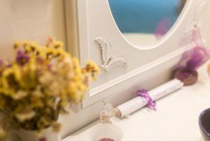 a bathroom sink with a candle and a vase of flowers at Apartments Adriana Flora in Dubrovnik +95 photos