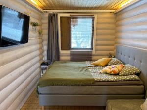 a small bedroom with a bed and a television at Vantaa Sauna Cottage in Vantaa