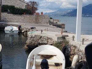 a boat is docked at a dock in the water at Kjara Apartments in Tivat
