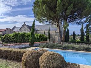 a house with a swimming pool and trees at Charmante Demeure 17ème 4ch-3sdb in Bioussac