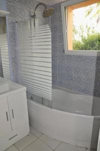 y baño con ducha, ventana y lavamanos. en Maison dans son écrin de verdure, en Plouvien 8 fotos más