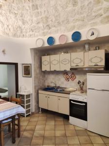 uma cozinha com armários brancos e pratos azuis na parede em U Casied em Montalbano