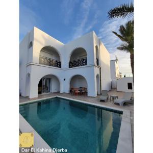 a house with a swimming pool in front of it at Dar El Kahina Djerba in Mezraya