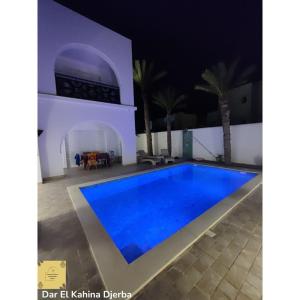 a villa with a swimming pool at night at Dar El Kahina Djerba in Mezraya