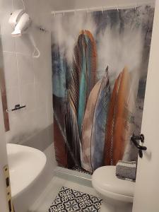 a bathroom with a shower curtain with feathers on it at Ανατολή in Veria
