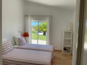 a bedroom with a bed and a sliding glass door at GARBE - Private Villa,Total Privacy, Infinity Swimming Pool, Close to Beaches in Porches +76 photos