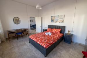 a bedroom with a bed with red pillows and a desk at The City House in Paphos City