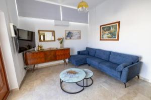 a living room with a blue couch and a table at The City House in Paphos