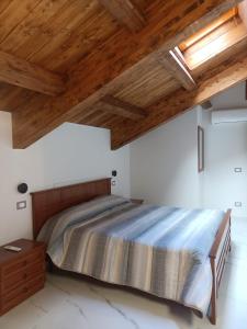 um quarto com uma cama e tectos em madeira em Colazione da Tiffany - Villa Bei Ricordi - B&B - Spa privata em Santa Lucia di Serino