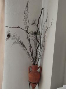 a vase with branches in it on a wall at Ανατολή in Veria