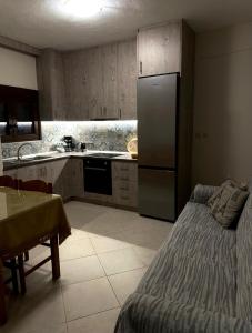 eine Küche mit einem Kühlschrank und einem Tisch darin in der Unterkunft Helen's House in Tríkala
