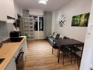 Il comprend une cuisine et un salon avec une table et un canapé. dans l'établissement Silva Całoroczny Apartament na Wyspie Sobieszewskiej, à Gdańsk