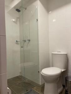 a bathroom with a toilet and a glass shower at Apartamento nuevo Manizales. in Manizales