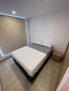 una camera con un letto in una piccola stanza di Apartamento nuevo Manizales. a Manizales