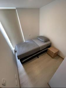 una piccola camera con letto e tavolo in legno di Apartamento nuevo Manizales. a Manizales