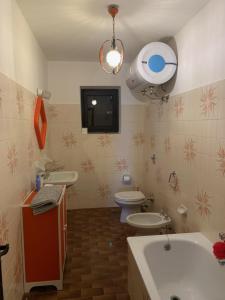 uma casa de banho com uma banheira, um WC e uma televisão. em Bielmonte Appartamenti em Bielmonte