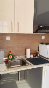 a kitchen counter with a sink and a microwave at City view apartments 4 in Serres