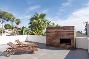 d'une terrasse avec 2 chaises et une cheminée. dans l'établissement Villa Lujo Castelldefels Barcelona, à Castelldefels