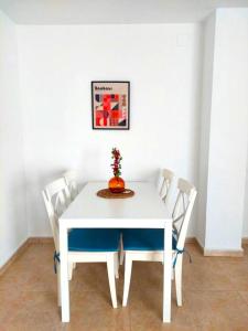 una mesa blanca con sillas y un jarrón encima en Paraná Center Apartment, en Sevilla
