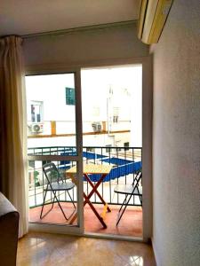 Habitación con vistas a un balcón con mesa y sillas. en Paraná Center Apartment, en Sevilla