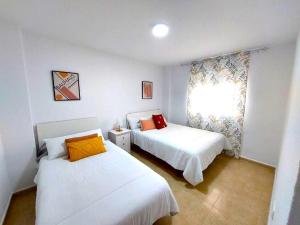 1 dormitorio con 2 camas y ventana en Paraná Center Apartment, en Sevilla
