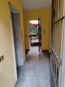 een hal met gele muren en een open deur bij Cozy Apartment Brera in Milaan