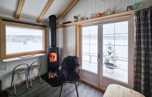 a living room with a stove and a window at Cozy Home In Gol With Sauna in Golsfjellet