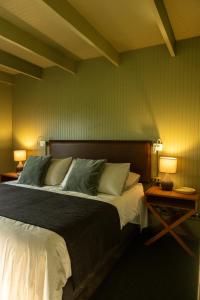 a bedroom with a large bed and two lamps at La Guarda in Catapilco
