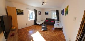 a living room with a couch and a wooden floor at Apartment 22 Omiš in Omiš