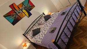a bedroom with a bed with purple sheets and pillows at Apartment 22 Omiš in Omiš