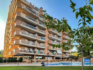 a tall apartment building with a swimming pool in front of it at Beachfront Family Retreat, Marina d'Or in Oropesa del Mar