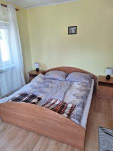 a bed with a wooden frame in a bedroom at Mieszkanie Dalia in Karwia