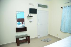 a bedroom with a bed and a mirror and a cabinet at Hotel V M Comfort in Bangalore