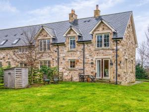an exterior view of a stone house with a yard at 2 Bed in Nr Beadnell 77990 in Ellingham