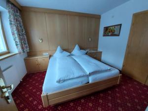ein Schlafzimmer mit einem großen weißen Bett in einem Zimmer in der Unterkunft Haus Monika und Haus Claudia in Mayrhofen