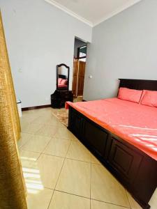 sypialnia z łóżkiem z czerwoną pościelą w obiekcie 1 Bedroom Apt - The Abode Mori w mieście Dar es Salaam
