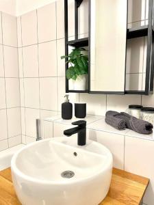 un lavabo blanc dans une salle de bain avec du carrelage blanc dans l'établissement Geräumiges Ferienhaus in Koblenz, à Coblence