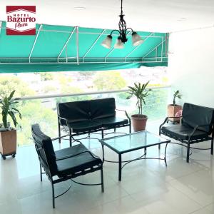 eine Lobby mit Stühlen, einem Tisch und einem Fenster in der Unterkunft Hotel bazurto plaza in Cartagena de Indias