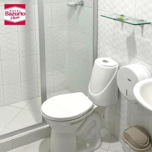 een witte badkamer met een toilet en een wastafel bij Hotel bazurto plaza in Cartagena