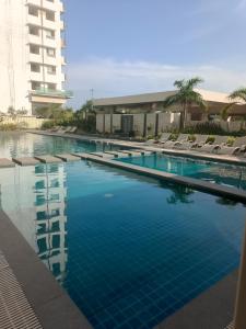 a large swimming pool with lounge chairs and a building at 3 J's STAYCATION in Bacolod