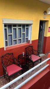 two chairs and a table on the porch of a building at Casa Rural Los Tilos Betancor in Moya