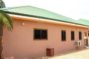 a building with a green roof and windows at Elizabeth Sampson Villa in Spintex