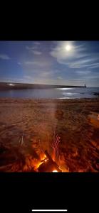 a fire on a beach with the ocean in the background at The View in Tynemouth